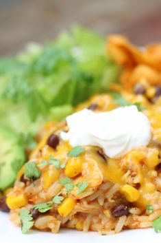 a white plate topped with rice covered in cheese and black beans next to lettuce