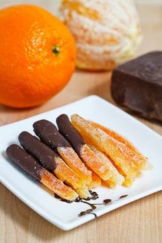 chocolate and orange desserts on a white plate with an orange in the back ground