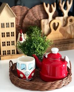 a red tea pot sitting on top of a wooden tray