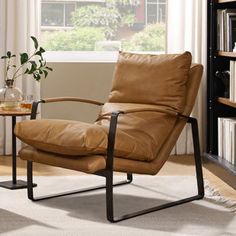 a brown leather chair sitting in front of a book shelf