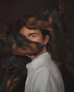 a man standing in front of two dogs with their heads on each other's shoulders