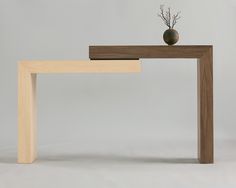 a wooden table with a vase on top of it and a shelf underneath the table