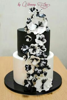 a black and white wedding cake with flowers on top