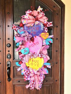 the front door is decorated with colorful hearts and ribbons that spell out, true love