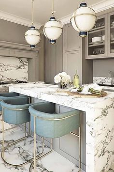 a kitchen with marble counter tops and blue stools in front of the bar area