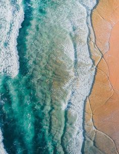 an aerial view of the ocean and sand