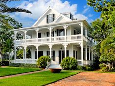 a large white house sitting on top of a lush green field