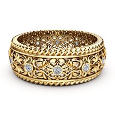 a gold ring with diamonds in the center and an intricate design on it's side