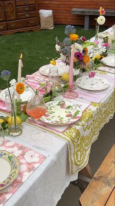 a table set with plates and flowers on it