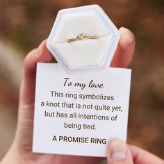 a person holding up a piece of paper with a ring on it that says to my love