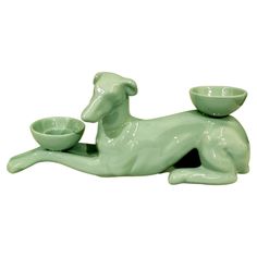 a green dog figurine with a bowl on it's back