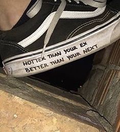 someone wearing black and white shoes with writing on the soles that says, hottie than your ex better than your next