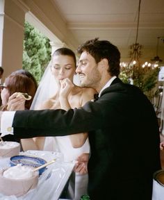 a bride and groom feeding each other cake