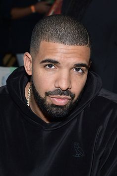 a close up of a person wearing a black hoodie and looking at the camera