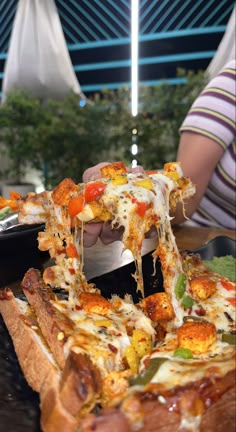 a person is cutting into a pizza with cheese and toppings