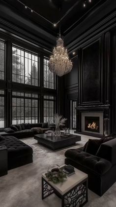 a large living room with black furniture and chandelier hanging from the ceiling,