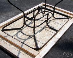 a metal frame sitting on top of plywood