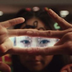 two people making the shape of a heart with their hands and eyes in front of them