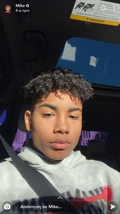 a young man sitting in the back seat of a car