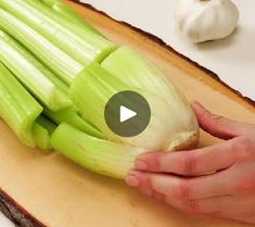 a person cutting up celery on top of a cutting board