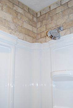 the shower head is above the bathtub in the bathroom, and it's not too far from the ceiling