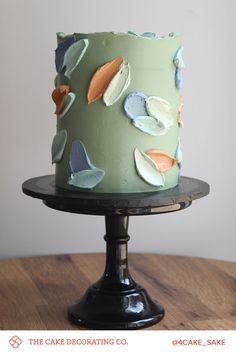 a cake decorated with leaves on top of a wooden table