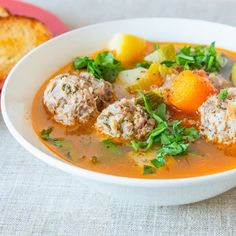 a bowl of soup with meatballs and vegetables