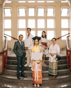 a group of people standing on top of a set of stairs next to each other