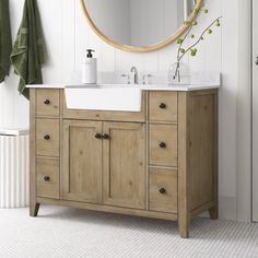 a bathroom with a sink, mirror and towels on the rack in front of it