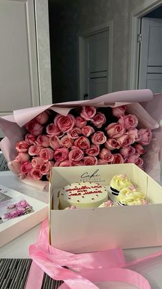 pink roses and cake in a box on a table