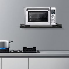 a toaster oven sitting on top of a counter next to a pot and pan