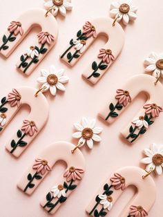 the letters are decorated with flowers and daisies on pink background, top view from above