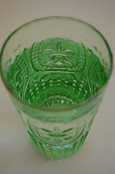 a green glass sitting on top of a table