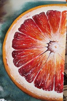 a grapefruit cut in half sitting on top of a white table next to a black surface