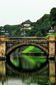 a bridge over a body of water with a castle in the backgroung