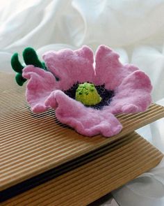 a pink flower sitting on top of a wooden box