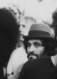 black and white photograph of man with hat in crowd