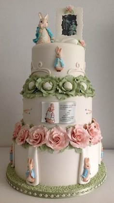 a three tiered cake decorated with flowers and rabbits