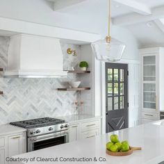 a kitchen with white cabinets and marble counter tops