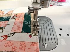 a close up of a sewing machine with fabric on it and a ruler in the background