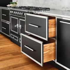 an image of a kitchen setting with black and silver appliances on the counter top, wood flooring