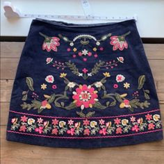 a blue skirt with flowers on it and a measuring tape in front of the skirt