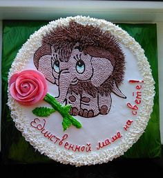 a birthday cake decorated with an elephant and a rose