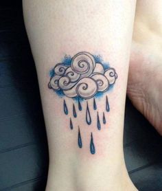 a woman's foot with a cloud and rain tattoo on the side of her leg