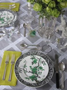 the table is set with silverware and green napkins