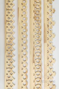 four wooden skis are lined up against a white background with holes in the wood