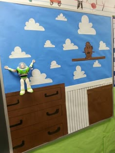 a bulletin board with an image of a man on top of a dresser in front of clouds