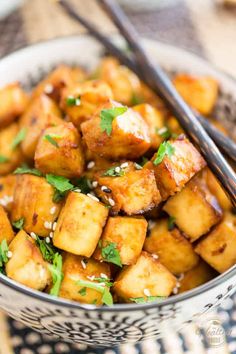 a bowl filled with tofu and chopsticks