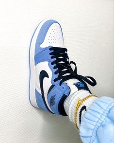 a pair of blue and white sneakers with gold accents