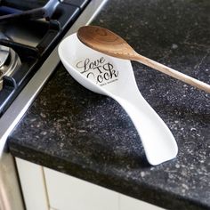 a wooden spoon sitting on top of a kitchen counter next to a stovetop oven